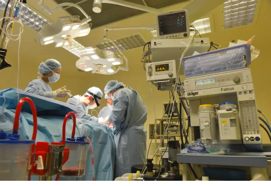 Doctors perform abdominal lavage as they remove the patient’s stomach during a six-hour surgery.