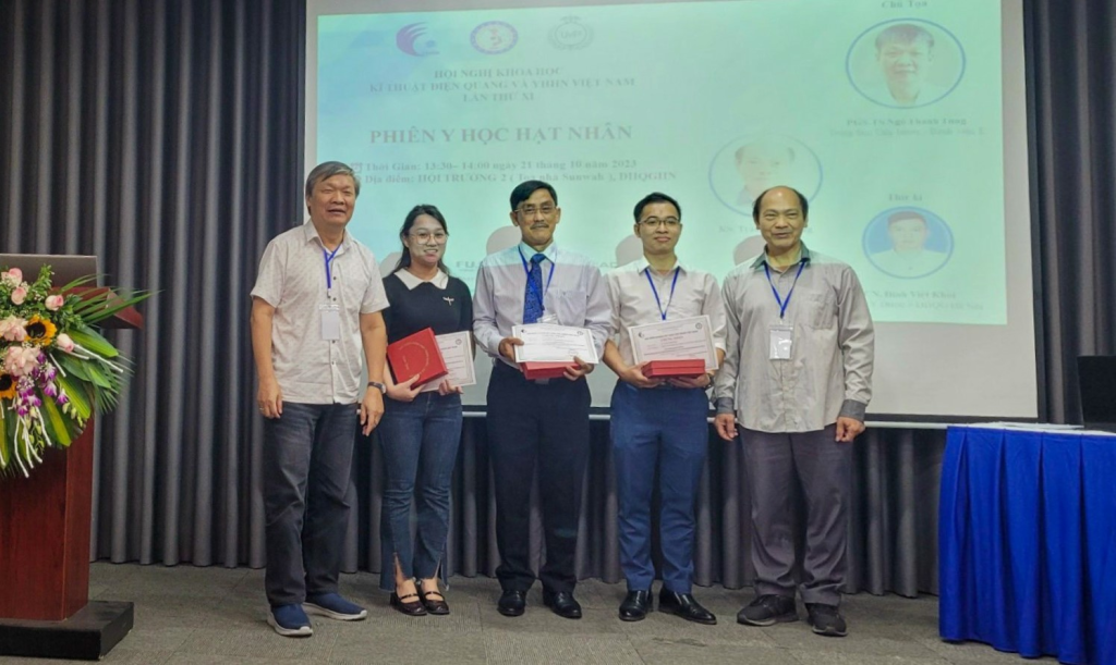 Mr Nguyen Chi Tam, Nuclear Medicine Department, FV Hospital (centre), receives an Outstanding Presenter certificate.