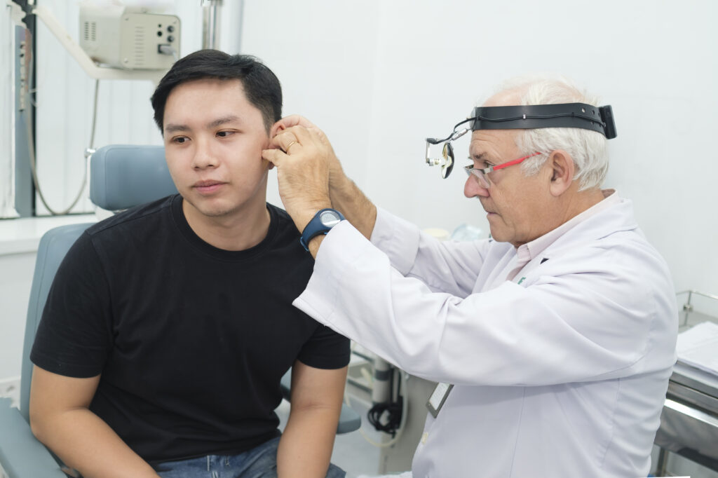 Bernard Colin, MD, PhD conducts medical examinations for patients.