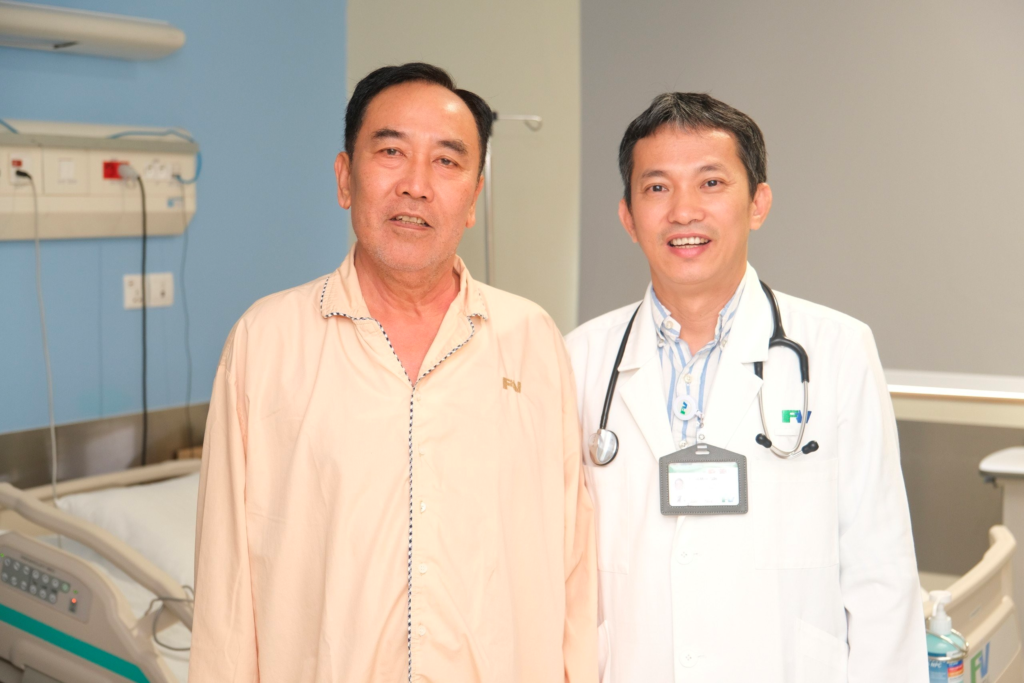 Patient Nguyen Quang Thanh poses for a photo with Ho Minh Tuan, MD, PhD before discharge