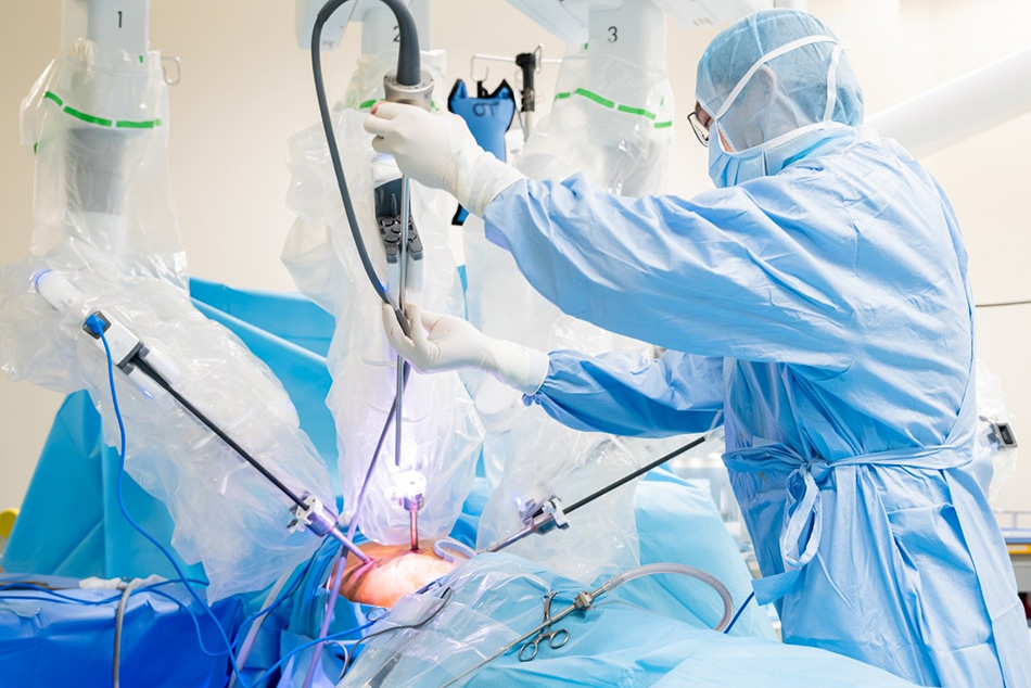 Bác sĩ phụ mổ đưa cánh tay phẫu thuật của Robot Da Vinci Xi vào vị trí được xác định