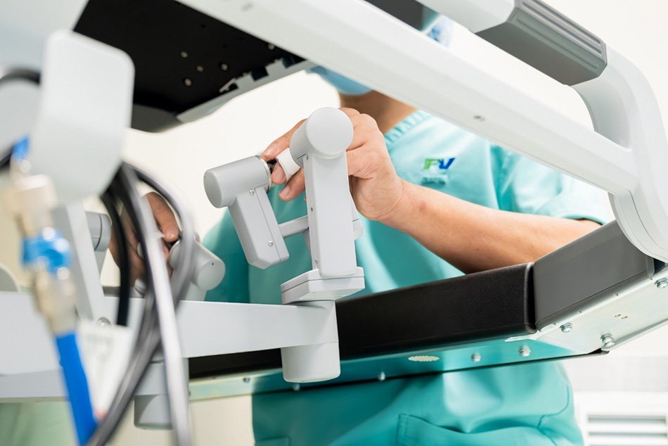 Bác sĩ phụ mổ đưa cánh tay phẫu thuật của Robot Da Vinci Xi vào vị trí được xác định